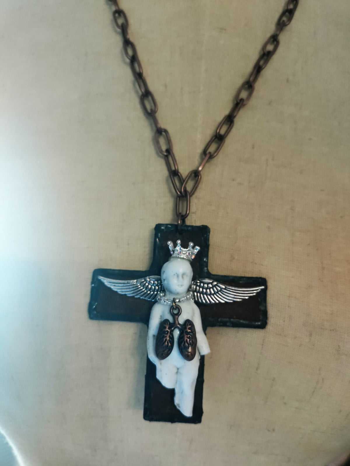 Charles' Last Breath necklace on mannequin, front view of the black cross pendant with copper oval-link chain