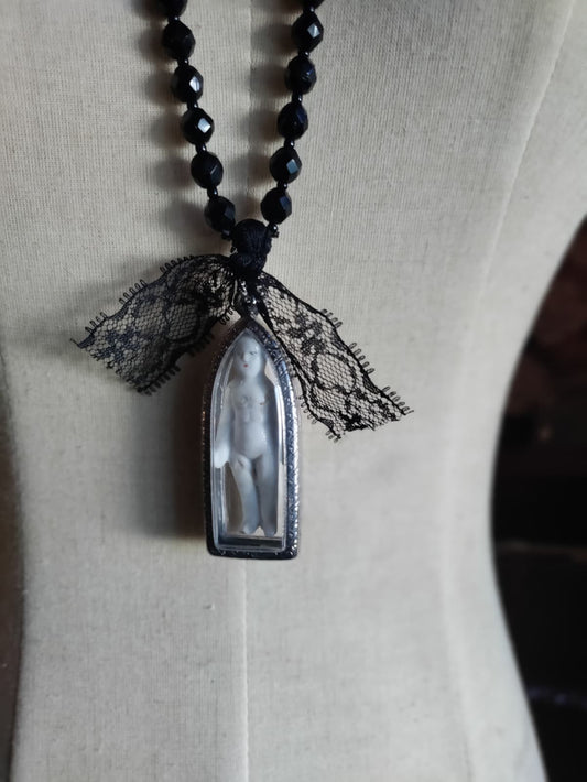 A Church Window in the Mourning, close-up of arched reliquary pendant and lace bow