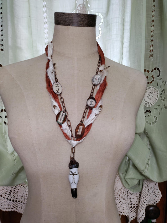 Porcelain antique doll leg, accented with rusted charms.