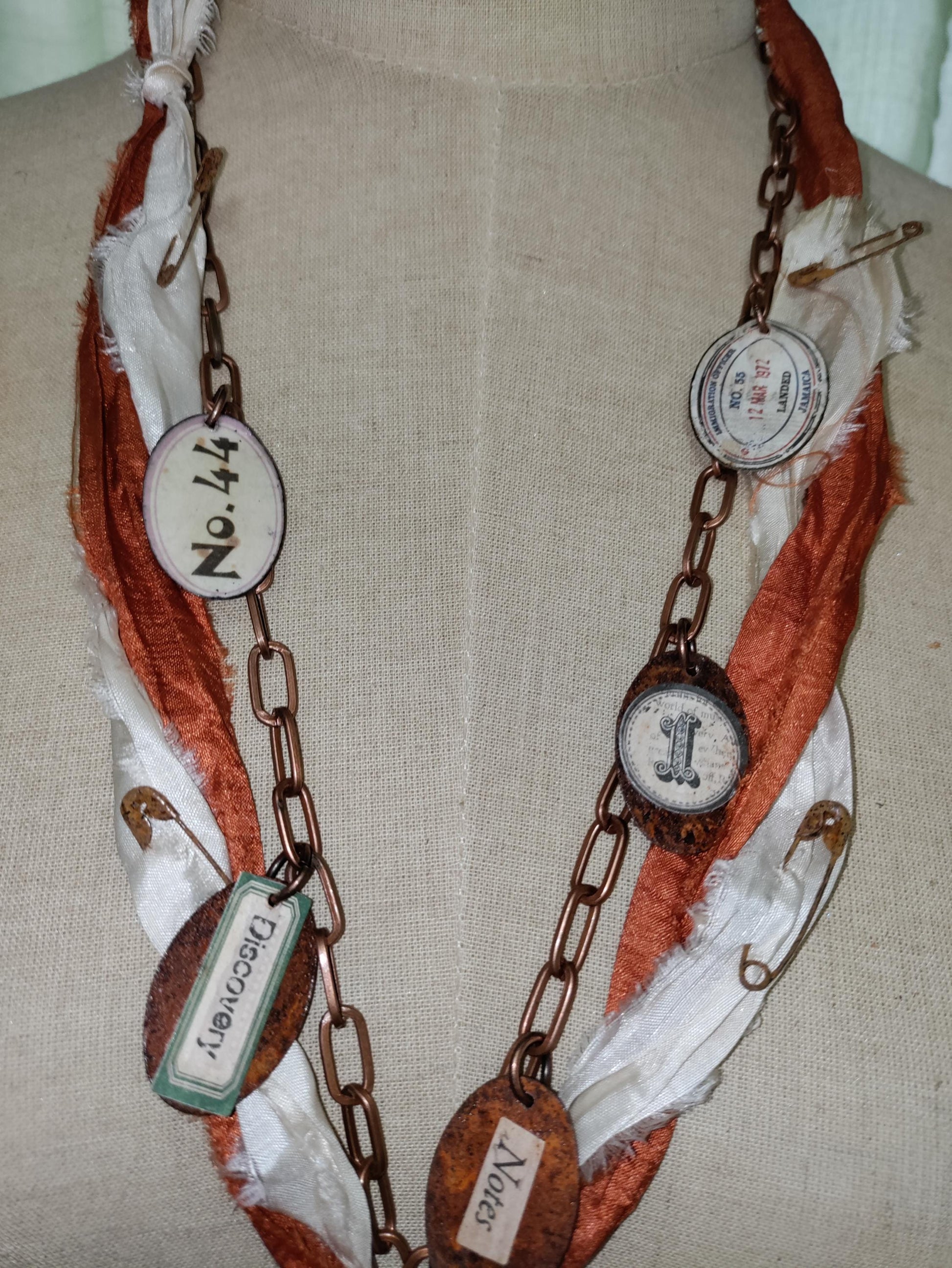 Porcelain antique doll leg, accented with rusted charms.