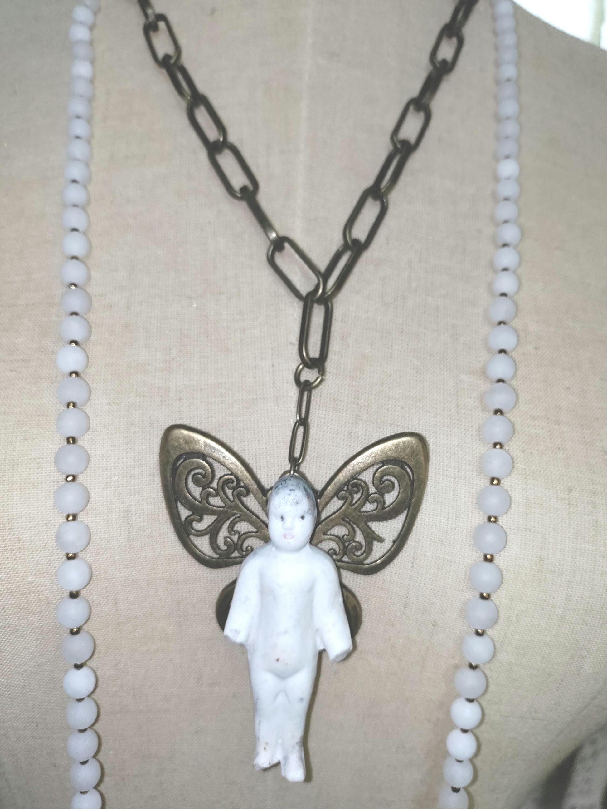 Frozen Charlotte with butterfly wings, with white frosted beads, necklace.