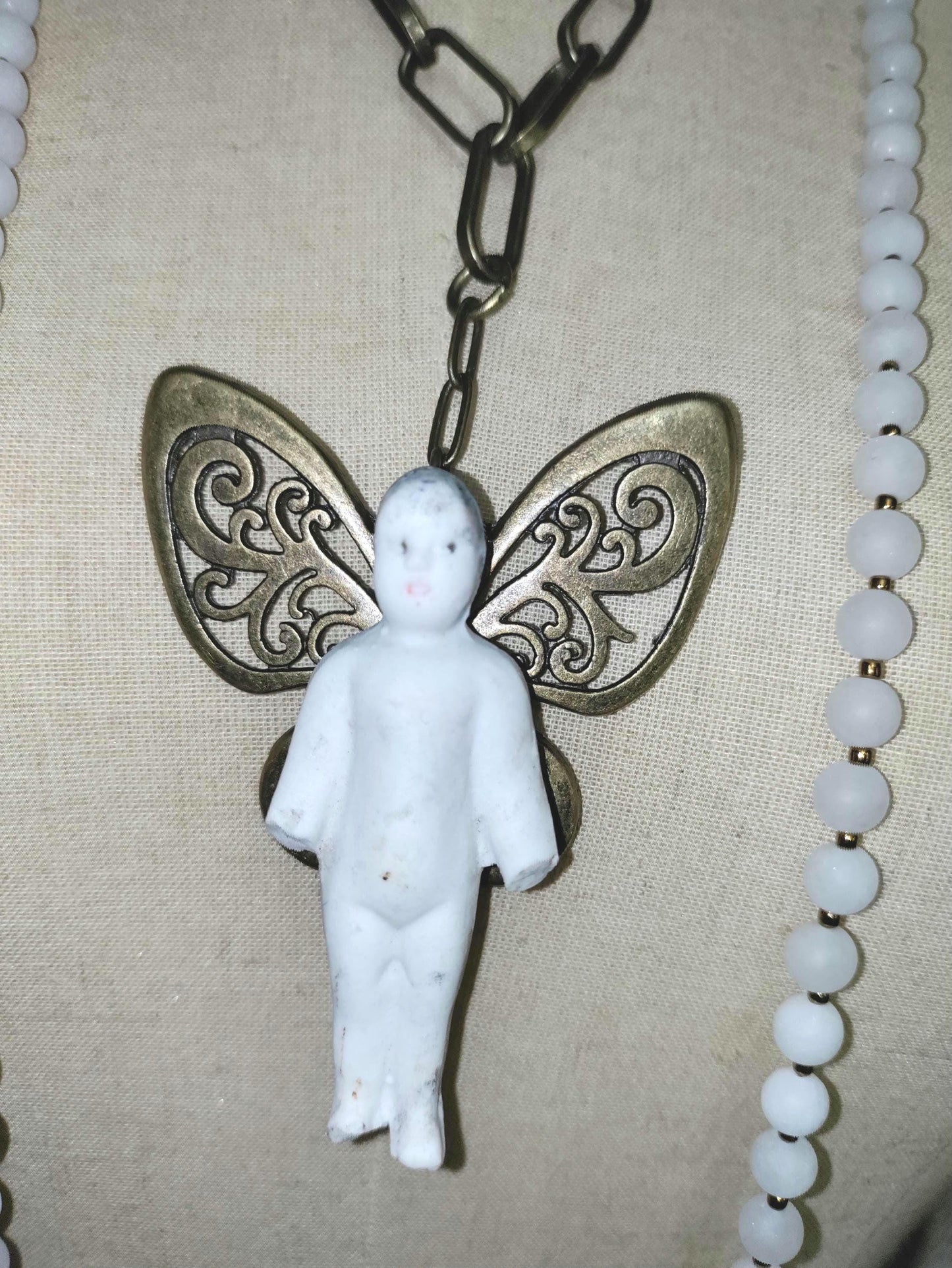 Frozen Charlotte with butterfly wings, with white frosted beads, necklace.