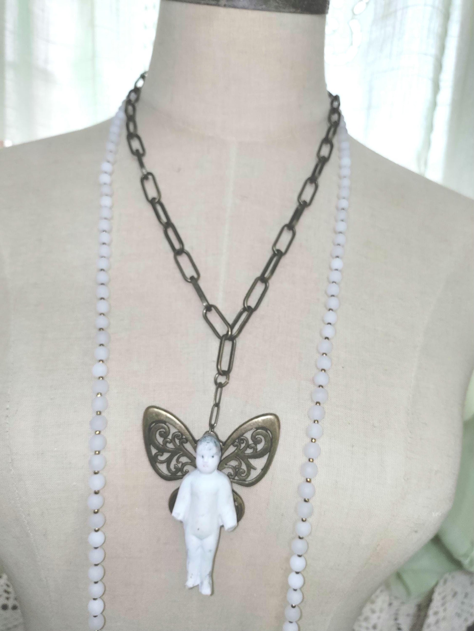 Frozen Charlotte with butterfly wings, with white frosted beads, necklace.