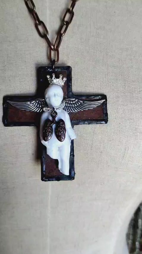 Video of the Charles' Last Breath necklace showing the black cross pendant with rhinestone crown, silver wings, and copper lungs charm in motion