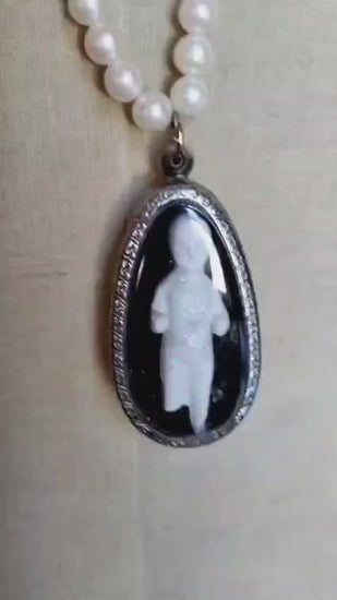 Video of the Reliquary necklace showing the oval silver bezel pendant with bisque doll figure in motion