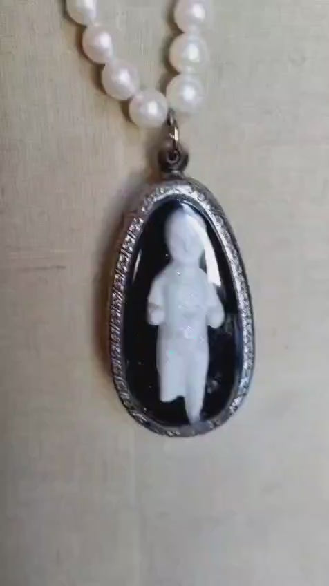 Video of the Reliquary necklace showing the oval silver bezel pendant with bisque doll figure in motion
