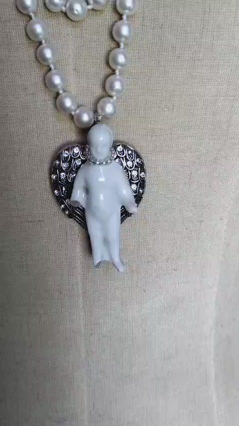 Video of the Ascending Frozen Charlotte necklace showing the knotted pearl strand and silver angel wing pendant from multiple angles