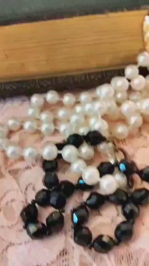Video of the Eternal Blooms Frozen Charlotte necklace showing the silver ribbon, arched bisque doll pendant, and rhinestone drop in motion